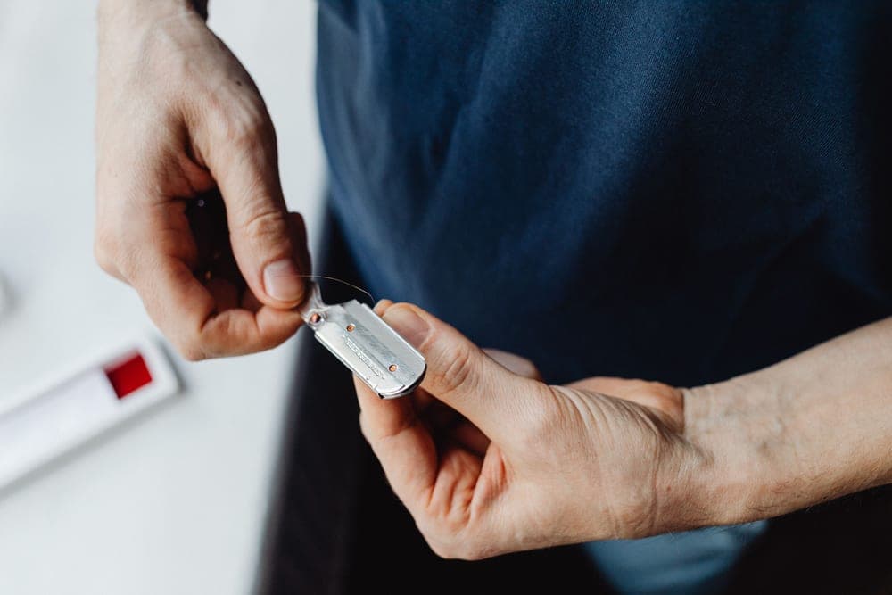 A man holding a safety razor before a first shave