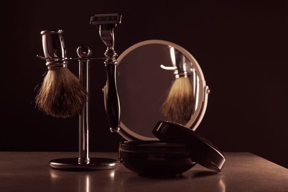 A shaving set of razor, brush and soap laid out together