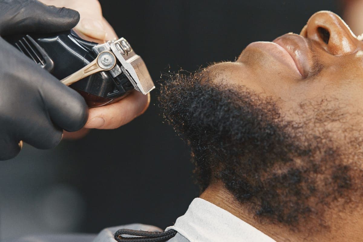 A cordless beard trimmer resting on a dark countertop