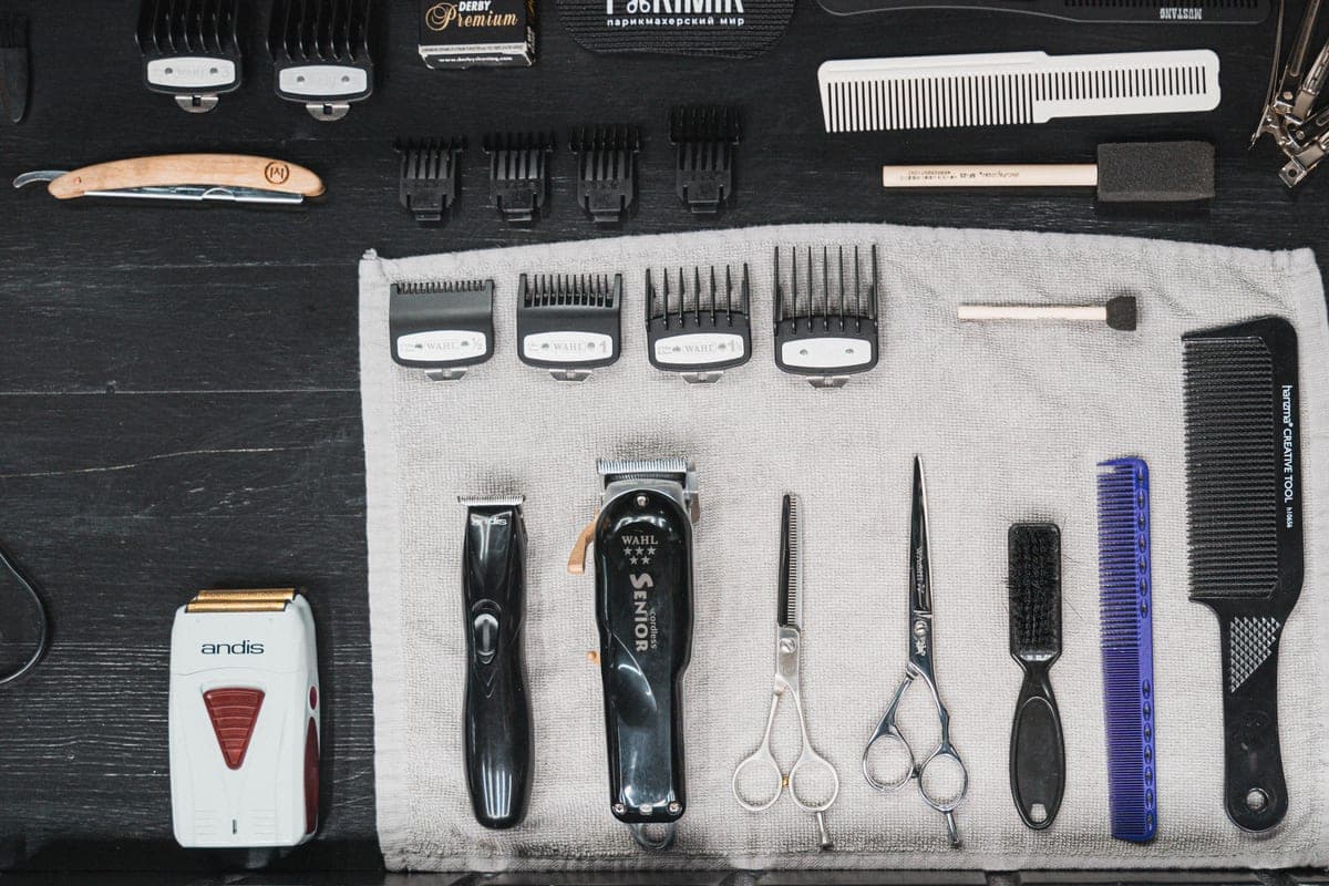Hair clippers and barber tools laid out on a flat surface
