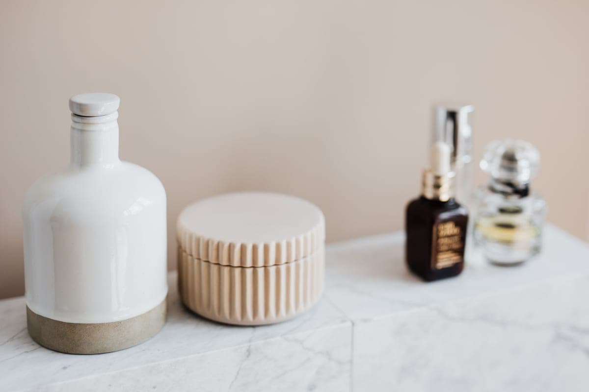 Plain skincare bottles arranged on a bathroom shelf
